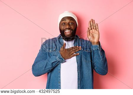 Image Of Smiling African-american Man Being Honest, Telling Truth, Hands On Heart And In Air, Making