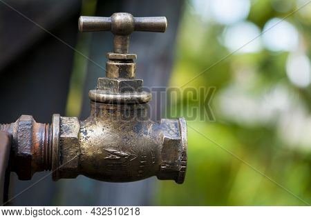 Old Brass Water Tap Isolated On A Light Background. Tap Valve. Old Copper Retro Faucet On A Rusty Pi