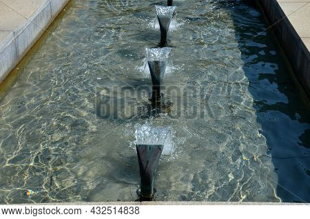 Swimming Pool With Fountains In The Shape Of An Opposite Cross On The Promenade In The Park On The S