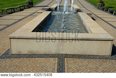 Swimming Pool With Fountains In The Shape Of An Opposite Cross On The Promenade In The Park On The S