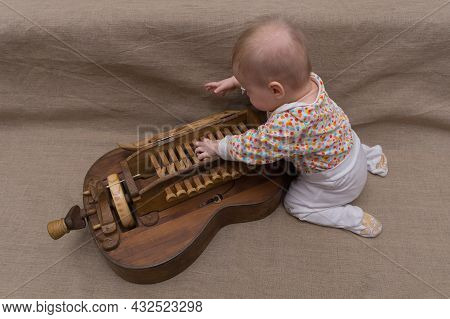 A Small Child Crawled Under The Cover Of The Keyboard Of An Ancient Musical Wooden Instrument - Hurd