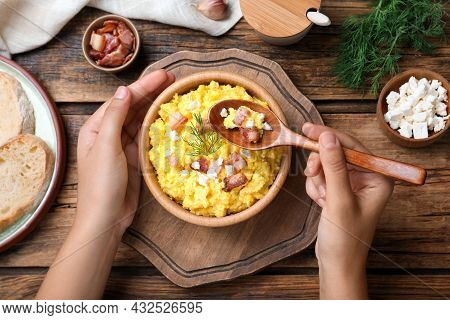 Woman Eating Banosh With Brynza And Pork Cracklings At Wooden Table, Top View. Traditional Ukrainian