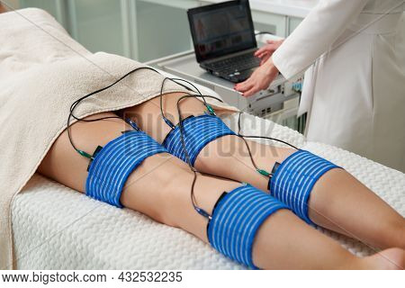 The Procedure Of Myostimulation On Legs Of A Woman In A Beauty Salon. Caring For The Body With Elect