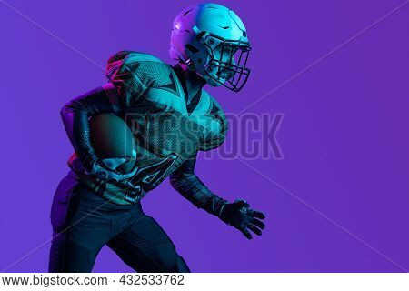 Cropped Portrait Of American Football Player In Special Unofrm Isolated Over Purple Studio Backgroun