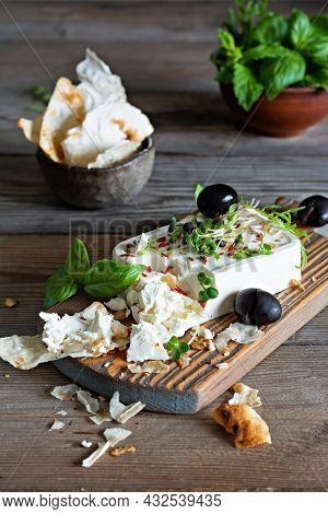 A Piece Of Fresh Feta Cheese (paneer) With Olives, Herbs, Spices And Slices Of Flatbread (tortilla, 