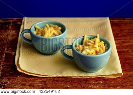 Stylized Vintage Retro Macaroni And Cheese Served In Small Tea Cups On Distressed Wooden Dining Room