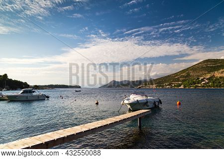 Fantastic Croatian Coast Sea View With Narrow Wooden Bridge And Small Boat At Sunset. Travel Dubrovn
