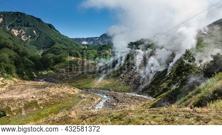 The Famous Valley Of Geysers, Kamchatka. In A Rocky Bed, Between The Mountains, A River Flows. Thick