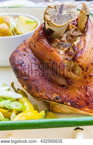 Traditional Czech Roasted Pork Knuckle Meat Served With Potatoes, Herbes And Vegetables