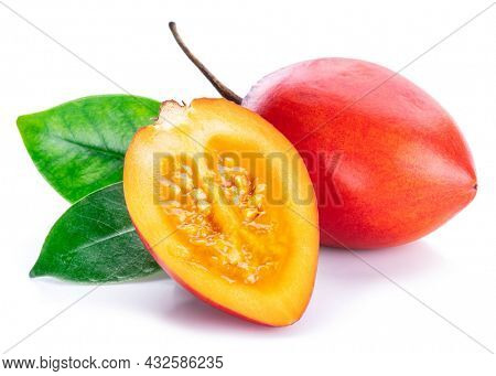 Ripe tamarillo fruits with slices and tamarillo leaves isolated on a white background.