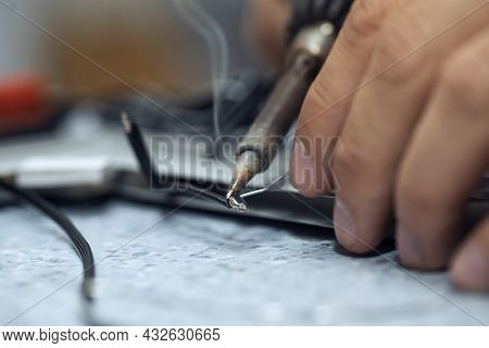 Wires Being Soldered Together With A Soldering Iron. Melting Solder Wire On Soldering Iron Tip
