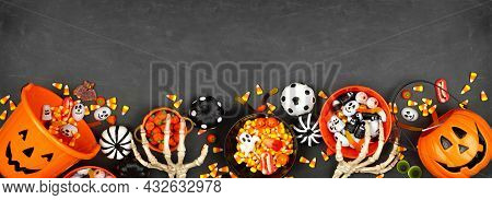 Halloween Trick Or Treat Bottom Border With Jack O Lantern Pails And Mixed Candy. Top View On A Blac