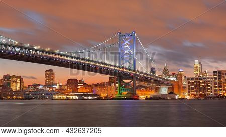 Philadelphia, Pennsylvania, USA skyline on the Delaware river with Ben Franklin Bridge at night.