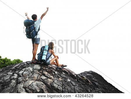 Two hikers with backpacks on top of a mountain isolated on a white background