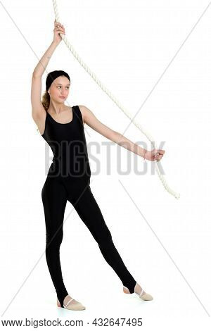 Attractive Sports Teen Girl Swinging On Rope Swing. Beautiful Girl Gymnast In Sportswear Doing Fitne