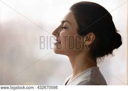 Calm Millennial Indian Lady Breath Deep Meditate With Closed Eyes
