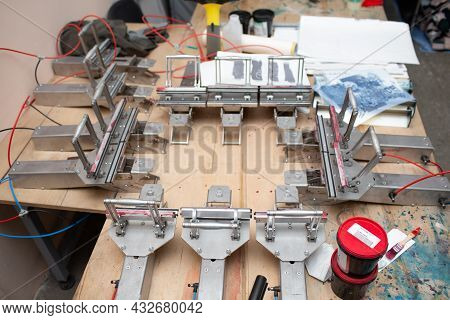 Serigraphy Silk Screen Print Process At Clothes Factory. Tensioner Frame, Squeegee And Plastisol Col