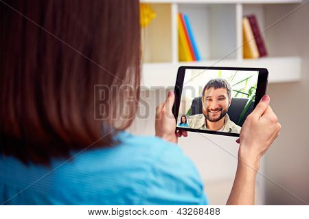 man and woman communicating through video chat on tablet pc