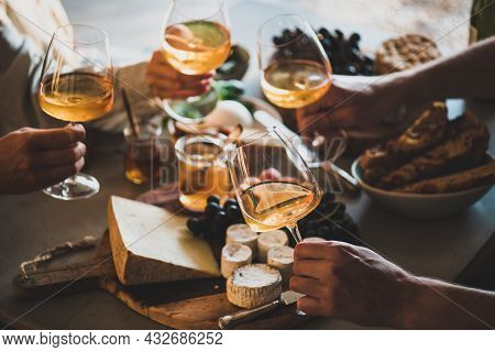 Hands Of People Holding Wineglasses With Orange Or Rose Wine