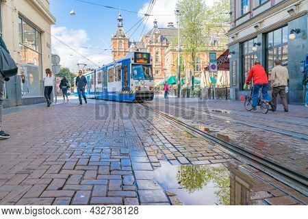 Amsterdam Netherlands - August 20 2017; Electric Public Transport Tram Entering City Street With Peo