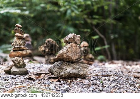 Balanced Stone Tower On Walkway Up The Mountain With Green Plants In The Background. Copy Space, No 