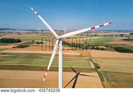Windmill Among Agricultural Fields. Wind Turbine Generator At Summer Day. Wind Energy Concept. Suist
