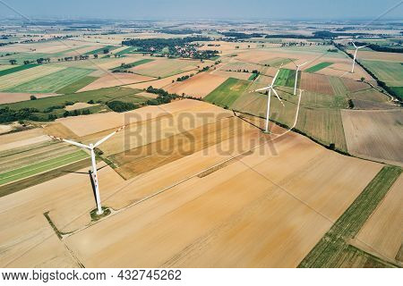 Windmill Among Agricultural Fields. Wind Turbine Generator At Summer Day. Wind Energy Concept. Suist