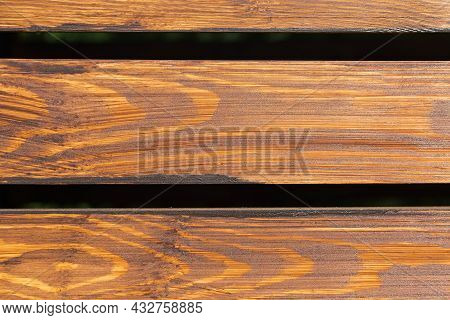 Fragment Of Fencing Built Of Wooden Planks Not Tightly Adjacent To Each Other, Covered With Mordant,