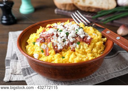 Tasty Banosh Served With Brynza And Pork Cracklings In Bowl On Table, Closeup. Traditional Ukrainian