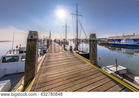 Various Ships Moored On A Wooden Quay In Harbor In Haringvliet Inlet, Zeeland Province The Netherlan