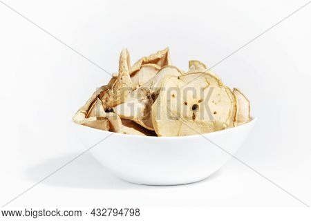 Dry Apple Chips In A White Plate Isolated On A White Background. Dehydrated Food. A Bunch Of Apple C