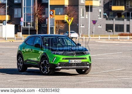 Riga, Latvia - 26 March, 2021: Green Electric Vehicle Opel Mokka-e In The Parking Lot On The Backgro