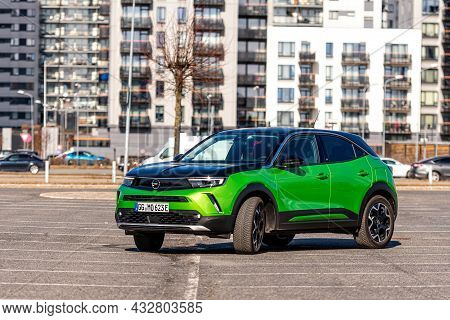 Riga, Latvia - 26 March, 2021: Green Electric Vehicle Opel Mokka-e In The Parking Lot On The Backgro