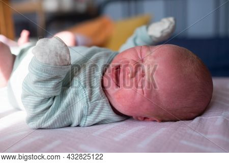 Little Crying Caucasian Newborn Baby On Her Bed Suffering From Colic