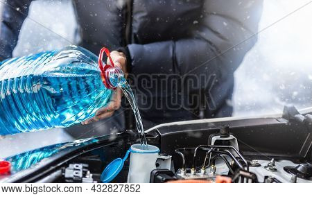 The Male Driver Pours Antifreeze Into The Tank To Spray The Windshield During A Snowstorm.