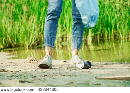Volunteer Woman Puts A Aluminium Can In A Trash Bag. Garbage Collection In The Forestor Nature.