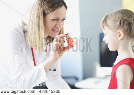 Pulmonologist Doctor Holding Hormonal Inhaler In Front Of Little Girl In Clinic.