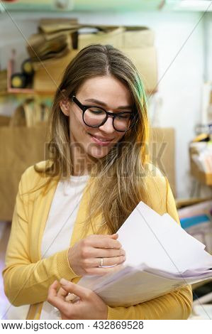 Small Business Owner Woman Checking Documents For Delivery. Successful Startup Entrepreneur In Packa