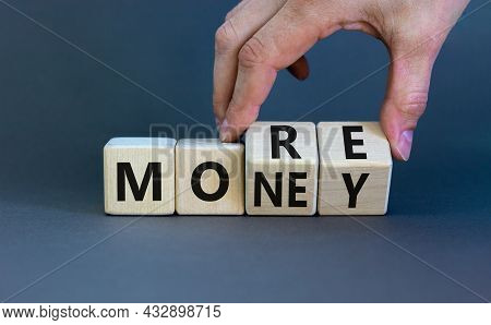 More Money Symbol. Businessman Turns Wooden Cubes And Changes The Word 'more' To 'money'. Beautiful 