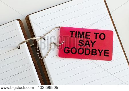 Time To Say Goodbye Written On A Red Card That Lies On A Notebook
