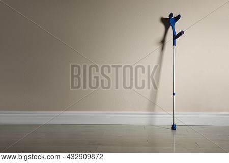 Elbow Crutch Near Color Wall. Space For Text