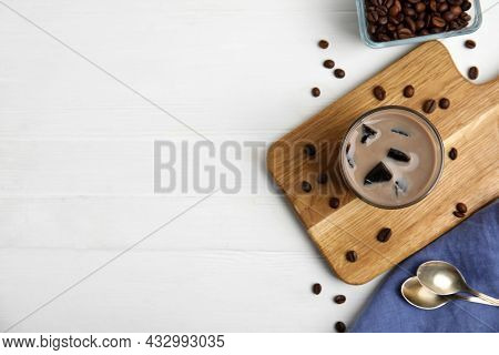 Glass Of Milk With Grass Jelly And Coffee Beans On White Wooden Table, Flat Lay. Space For Text