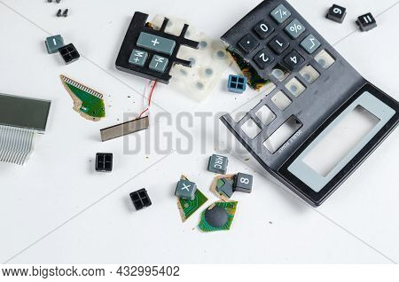 A Shattered Calculator On A White Background. Buttons, Pieces Of The Case, Board, Solar Panel. Selec