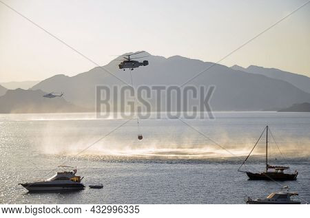 Russian KA-32 helicopter draws water from the sea to extinguish a forest fire. 30 July, 2021. Marmaris,Turkey