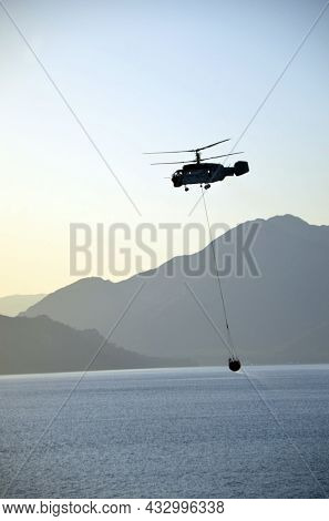 Russian KA-32 helicopter draws water from the sea to extinguish a forest fire. 30 July, 2021. Marmaris,Turkey