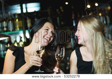 Two Female Friends Toasting In A Nightclub