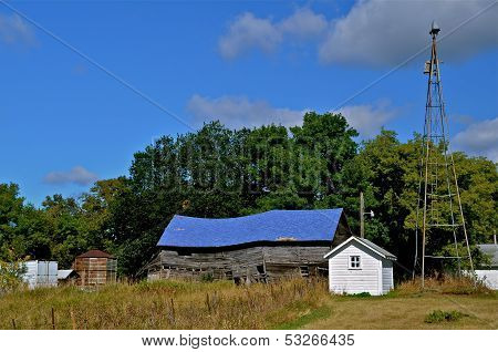 Dilapidated barn with a blue roof