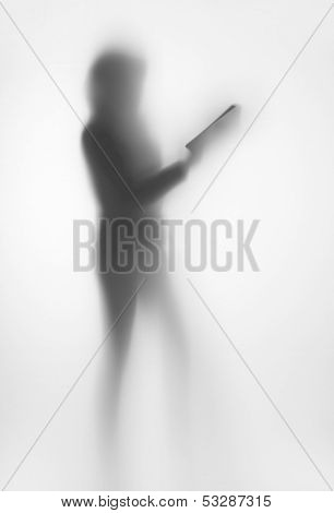 Human standing female body silhouette with book behind a curtain