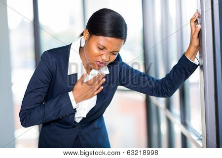 young african american businesswoman having heart attack or chest pain