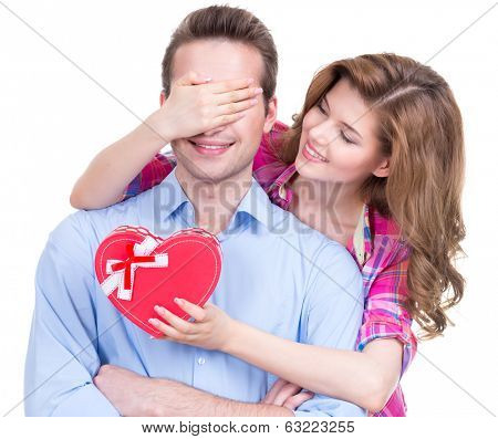 Portrait of beautiful happy couple isolated on white background. Attractive women make a surprise to man.
